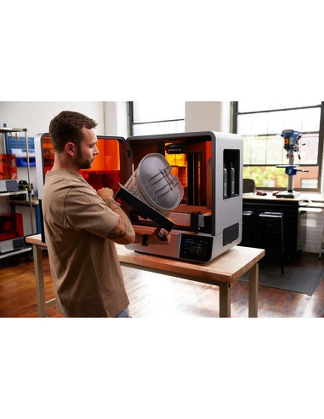 Operator wyjmuje platformę z drukarki Formlabs Form 4L